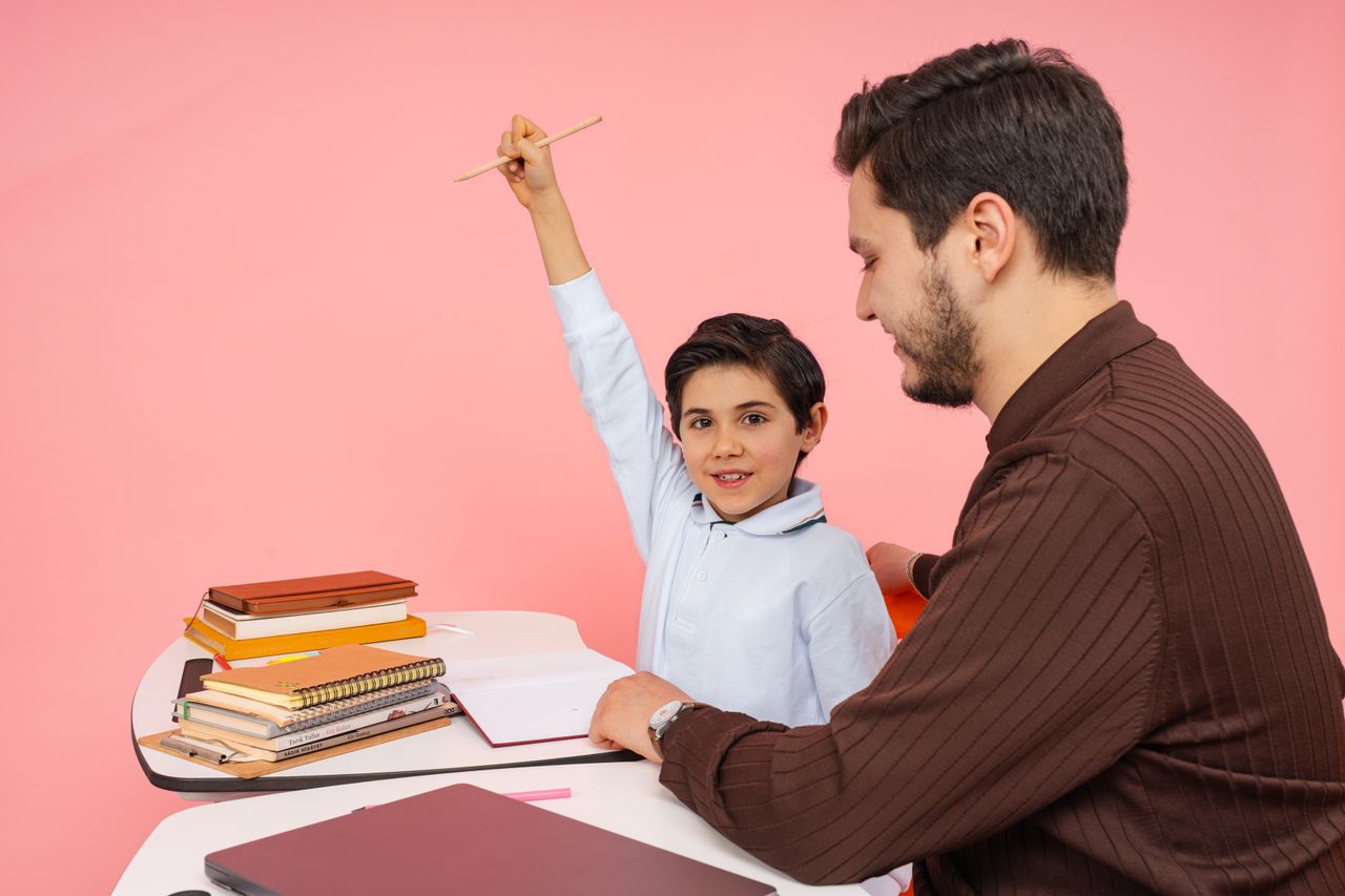 Oferta Teacher aids enthusiastic student in classroom setting, enhancing learning experience.