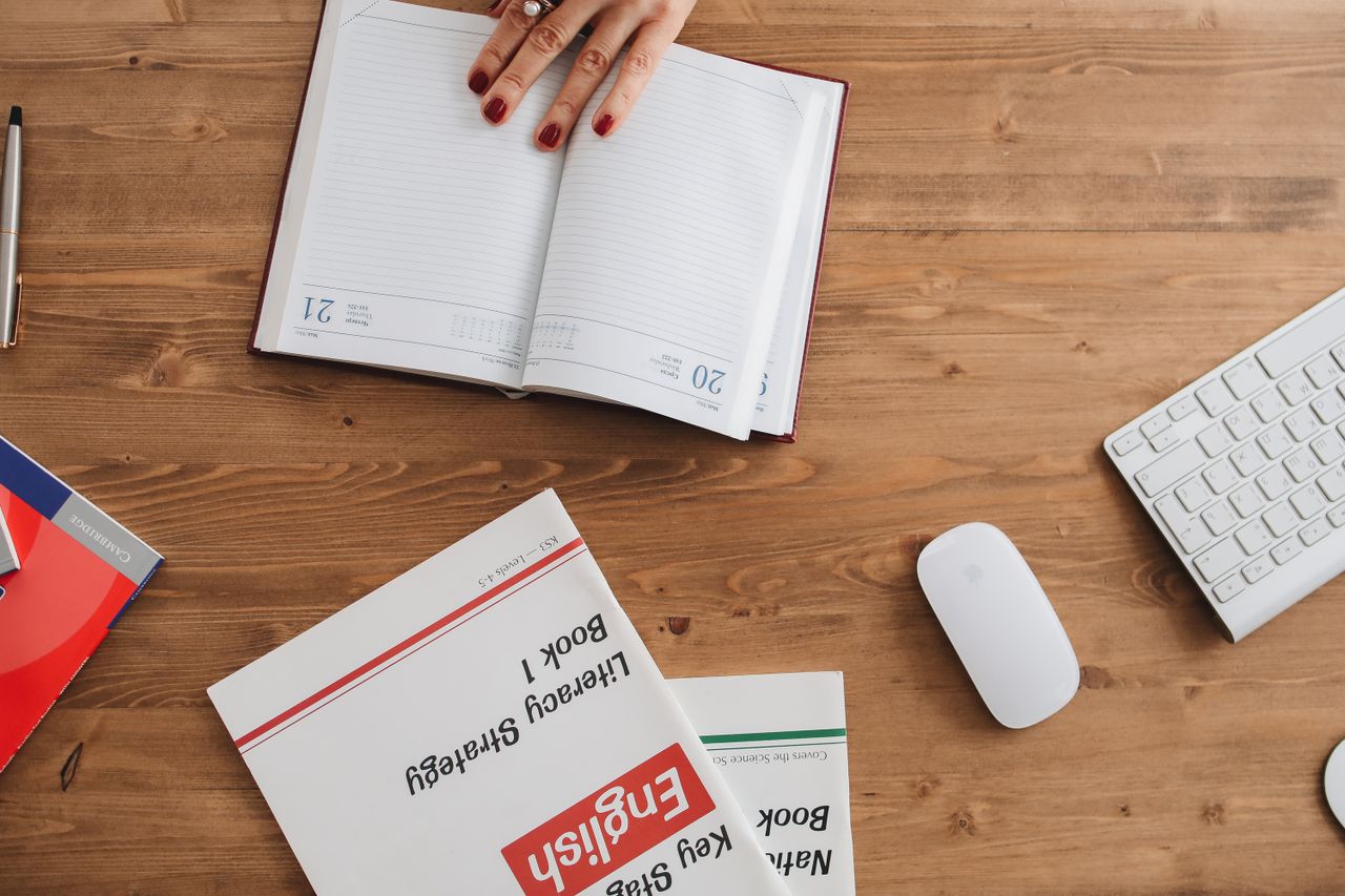 Oferta Open planner and English workbooks on a wooden desk, ideal for study-themed visuals.